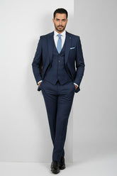 Man wearing black tailored suit with satin lapels and modern fit.